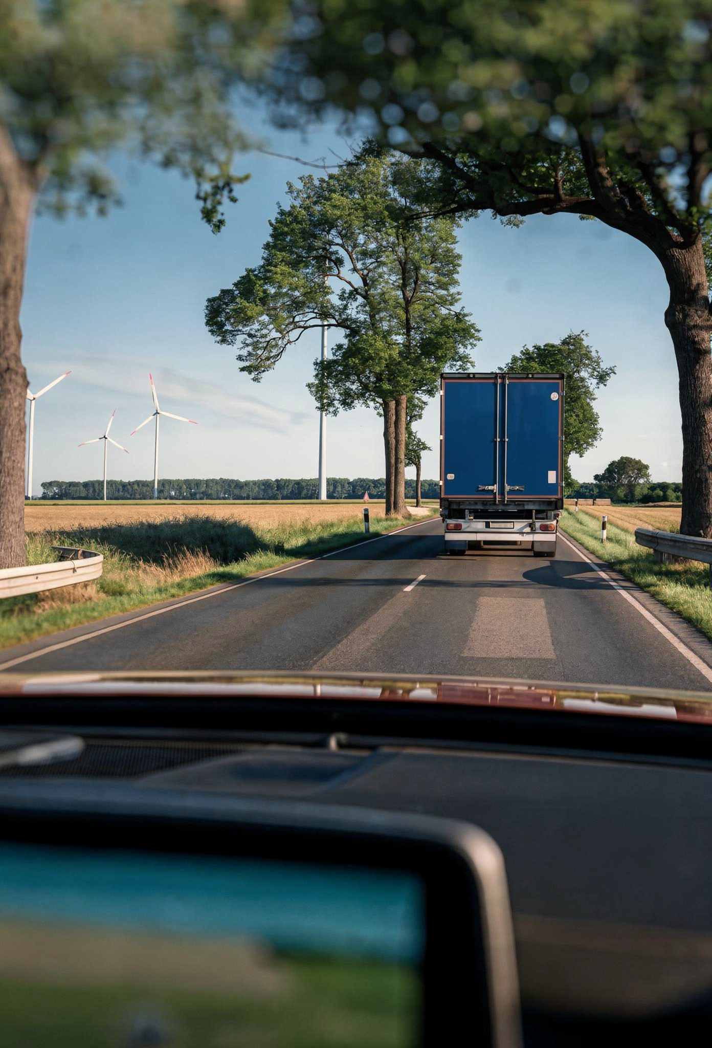 Security Escorts for trucks LKW mit besonderem Gut von hinten auf einer Landstrasse. Sicht aus dem Cockpit eines Begleitfahrzeuges, das dem LKW folgt.